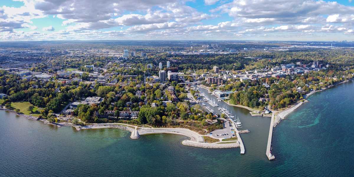 Aerial view of Oakville, Ontario, showing the Lake Ontario shoreline, a harbour with a marina and piers, and the town behind.